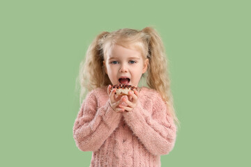 Cute little girl with donut on green background