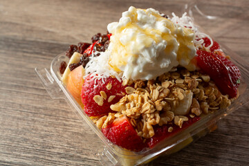 A closeup view of a fruit salad in a plastic container.