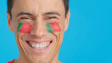 Man with a portuguese flag painted on the face smiling