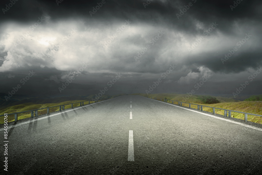 Wall mural A long, empty road with a cloudy sky above