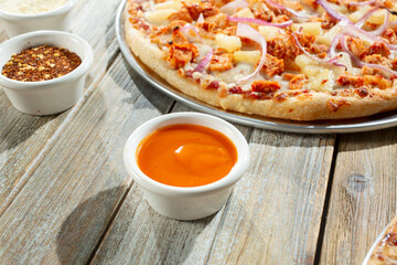 A view of a condiment cup of Buffalo wings sauce.