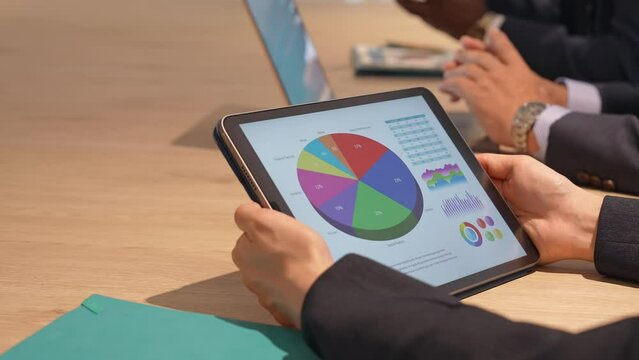 Business people having a meeting while looking at a tablet screen