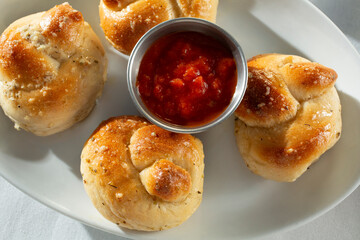 A top down view of a plate of garlic knots.