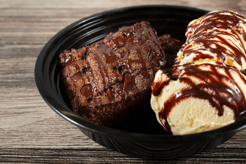 A view of a bowl of brownies and ice cream.