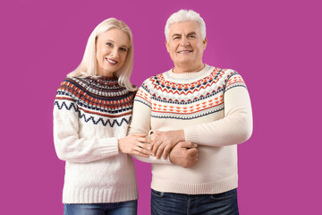 Happy mature couple on purple background