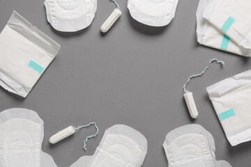 Frame made of menstrual pads and tampons on grey background