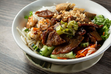 Fototapeta premium A closeup view of a bowl of Vietnamese bun, featuring grilled pork and shrimp.