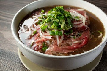A closeup view of a bowl of rare wagyu beef pho.