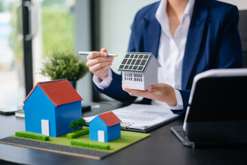 balancing the property sector The real estate agent is explaining the house style to see the house design and the purchase agreement. model house and comdo