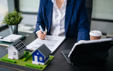 balancing the property sector The real estate agent is explaining the house style to see the house design and the purchase agreement. model house and comdo