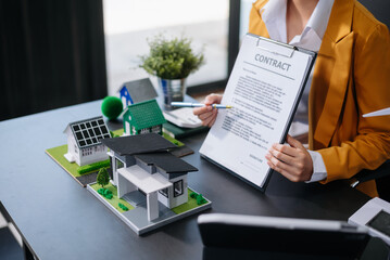 balancing the property sector The real estate agent is explaining the house style to see the house design and the purchase agreement. model house and comdo