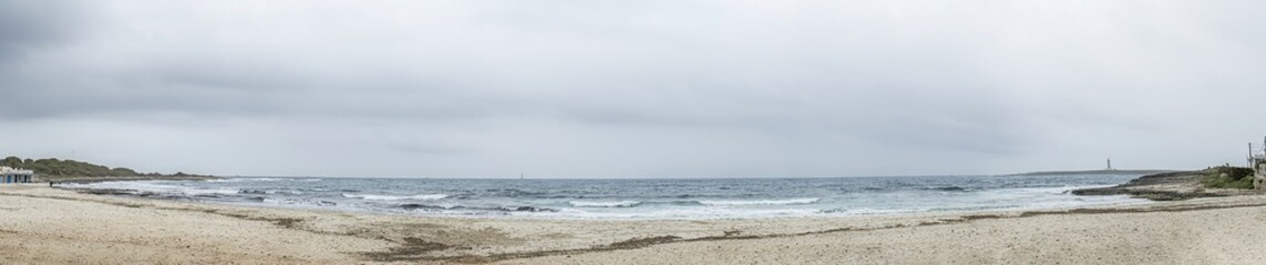 Distant Lighthouse View from Punta Prima Beach
