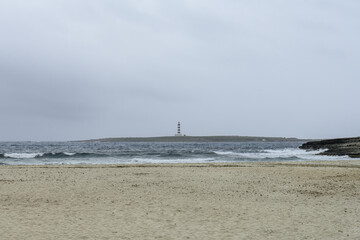 Distant Lighthouse View from Punta Prima Beach