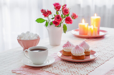 cup of coffee with dessert and roses on table