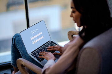 Close-up of a woman woman using laptop and igning in to her email account