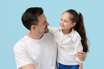 Father and his little daughter on blue background. Father's Day celebration