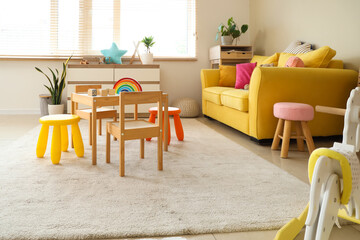 Interior of modern playroom with toys and rocking horse in kindergarten