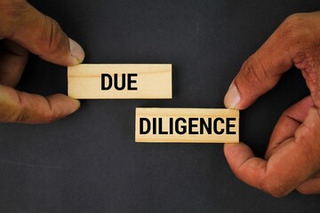 hand holding a stick with the word due diligence. the concept of self-integrity. the concept of persistence.