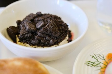 A dessert of cookies and cream cheesecake with raspberry coulis served on a business class flight from Sydney, Australia to Kuala Lumpur, Malaysia