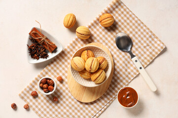 Bowls with tasty walnut shaped cookies, boiled condensed milk and ingredients on white grunge table