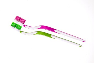 Closeup of two toothbrushes isolated on white background.
