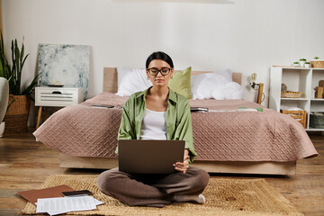 Casual woman immersed in work, seated on floor with laptop.