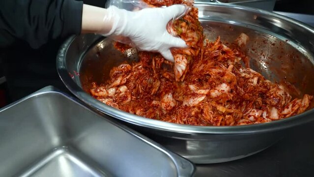 Freshly chopped Chinese cabbage in a bowl, being seasoned with a rich tomato sauce for convenient preparation.