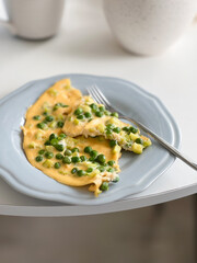 Omelette or frittata with green peas on a plate, healthy breakfast meal