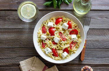 Orzo pasta with white cheese, tomatoes and olives. Healthy eating. Vegetarian food.