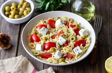 Orzo pasta with white cheese, tomatoes and olives. Healthy eating. Vegetarian food.