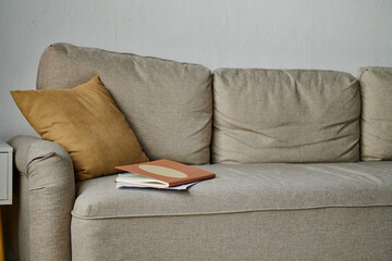 A comfortable couch with a book resting on top of it.
