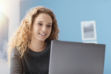 Smiling girl connecting with her laptop