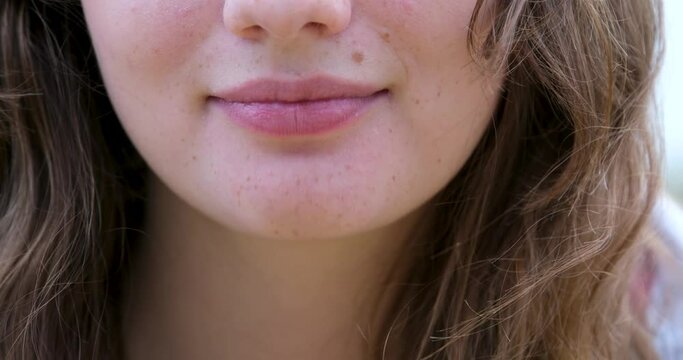 girl playfully grimaces at the camera and sticks out her tongue. A young woman sticks her tongue out to the side and then forward with the long tongue of a teenager
