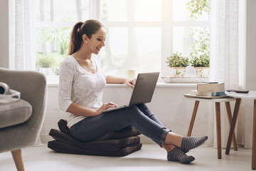 Young woman networking with her laptop at home