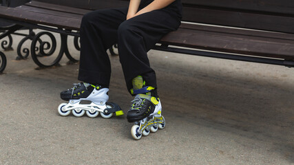 Close up roller blades. Roller skating girl kid in park rollerblading on inline skates.