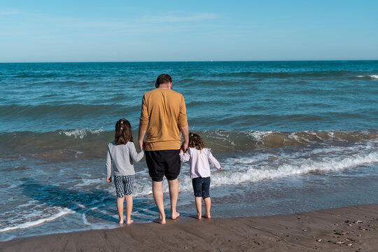 An unforgettable family day at the beach: Dad and daughters ride the waves together