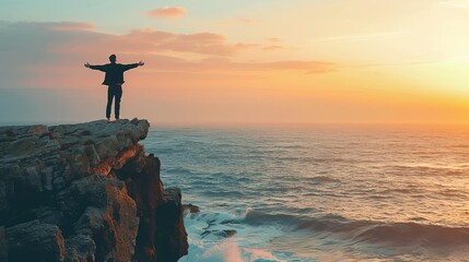 A man standing on a cliff, looking out over the ocean at sunset, arms outstretched, feeling free and at peace, waves crashing below