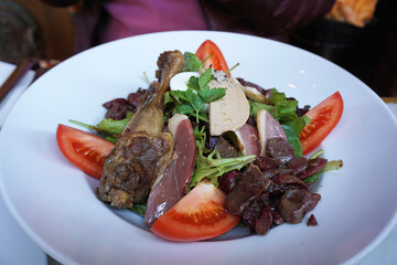 Close up Gourmet Salad (Salade Gourmande) bowl- Mesclun, Foie Gras, smoked duck, tomato, gizzard, duck leg and boiled egg