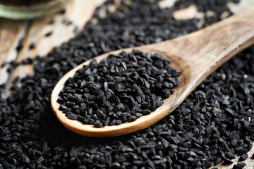 Black cumin or Nigella sativa seeds on a wooden spoon
