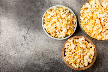 Tasty popcorn on woodenbackground. Cinema and entertainment concept. Movie night with popcorn.Cheese and caramel popcorn. Delicious appetizer, snack. Place for text. Copy space.Banner