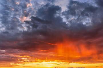 A vibrant sunset or sunrise sky with cloudscape in soft magenta, pink and orange tones as a background or texture