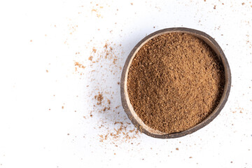 Coconut palm sugar in coconut bowl isolated on white background. Top view. Copy space
