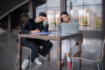Latino man and African American businessperson brainstorming startup small business strategy together. Young multiracial businesswoman and colleague serious working on planning. Diversity people team.