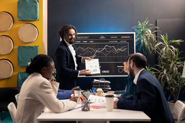 Corporation workers addressing project updates and objectives in a boardroom meeting, establishing...