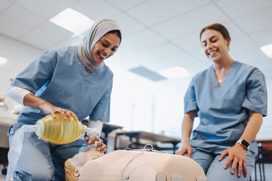Female student with a hijab practicing CPR during medical simulation