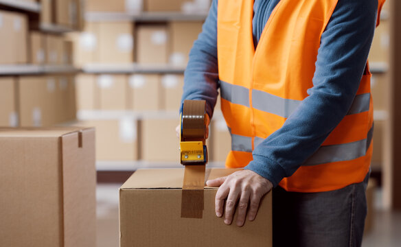 Warehouse packer sealing a delivery box