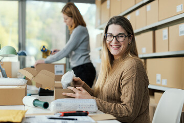 Woman putting goods in a delivery box