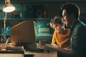 Caring father using a computer with his son