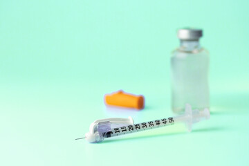 medical syringe and a bottle of injectable medication in a pharmaceutical laboratory blue background copy space © VICTOR