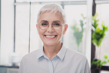 Photo of smiling positive mature lady specialist formalwear working indoors workplace workstation